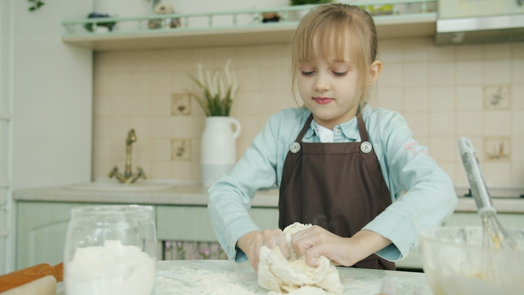 Hands kneading dough on a floured wooden table